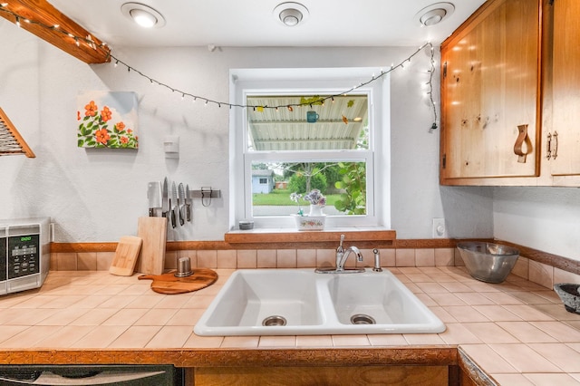 kitchen featuring tile counters and sink