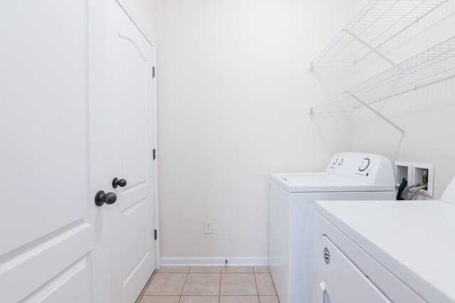 laundry area featuring separate washer and dryer and light tile patterned flooring