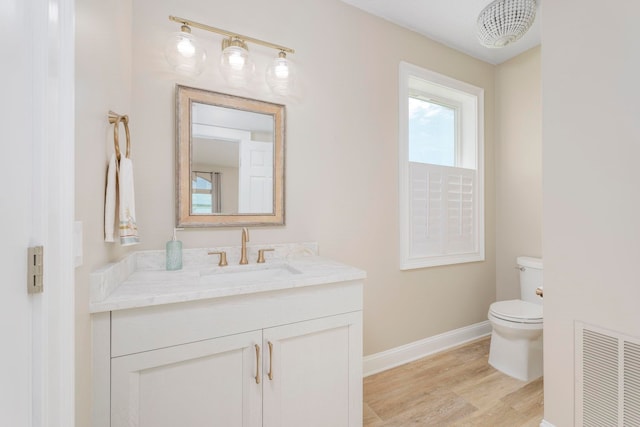 bathroom featuring vanity, wood-type flooring, and toilet