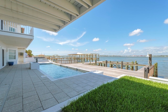 view of swimming pool with a patio area, a water view, and a boat dock