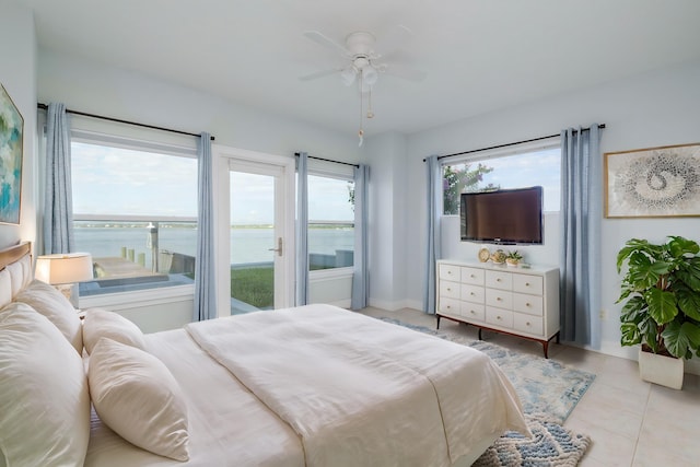 tiled bedroom featuring ceiling fan and a water view