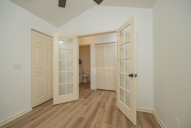 unfurnished bedroom featuring vaulted ceiling, french doors, ceiling fan, and light wood-type flooring