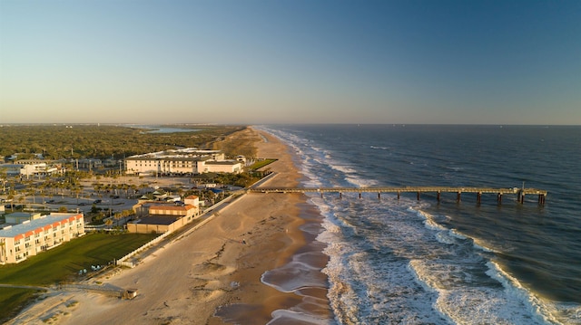 aerial view at dusk featuring a beach view and a water view