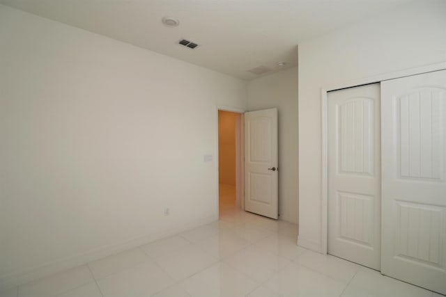 unfurnished bedroom featuring light tile patterned floors and a closet