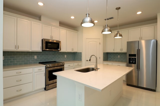 kitchen featuring white cabinetry, sink, tasteful backsplash, a center island with sink, and appliances with stainless steel finishes