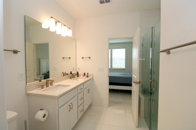 bathroom featuring tile patterned flooring, vanity, toilet, and a shower with door