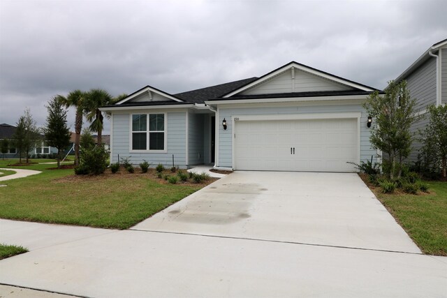 ranch-style house featuring a garage and a front lawn