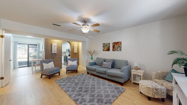 living room with wood-type flooring and ceiling fan