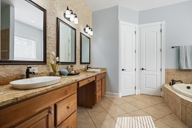 bathroom with tile patterned floors, vanity, and a relaxing tiled tub