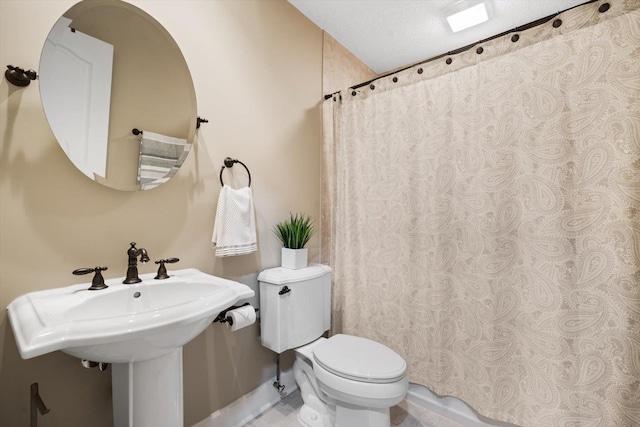 bathroom with sink, toilet, and a textured ceiling