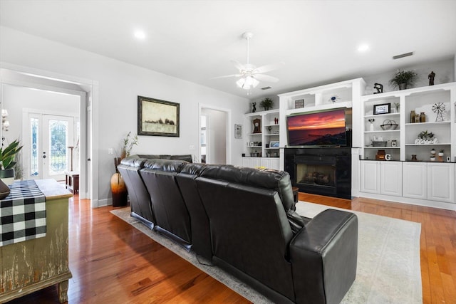 living room featuring ceiling fan, hardwood / wood-style floors, and french doors