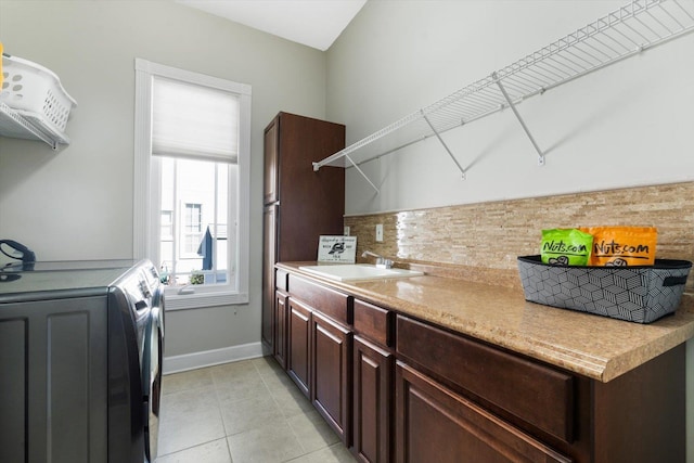 washroom featuring sink, light tile patterned flooring, and washer / dryer