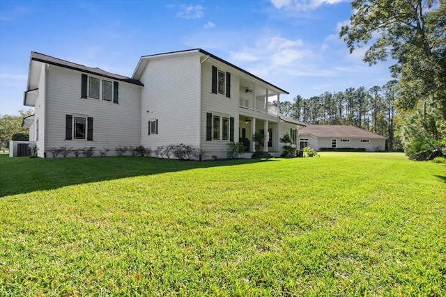 back of house featuring a yard and a balcony