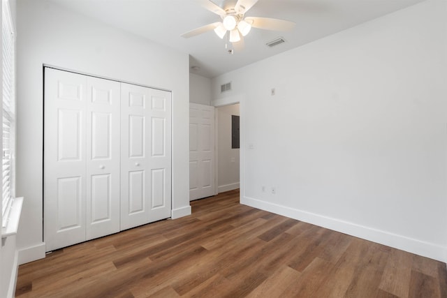 unfurnished bedroom featuring a closet, wood finished floors, visible vents, and baseboards