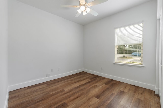 empty room with dark wood-style floors, ceiling fan, and baseboards