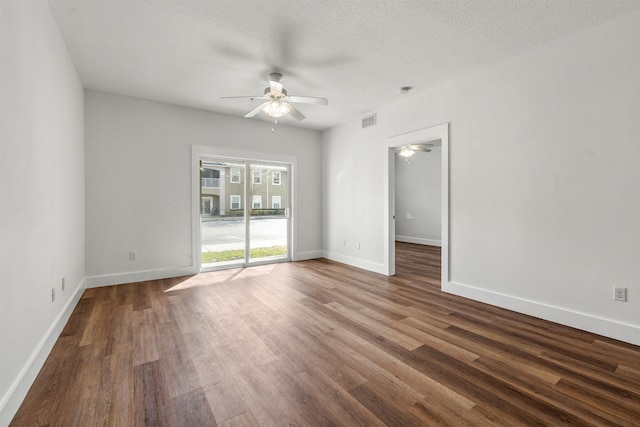 unfurnished room featuring baseboards, visible vents, ceiling fan, dark wood-style flooring, and a textured ceiling