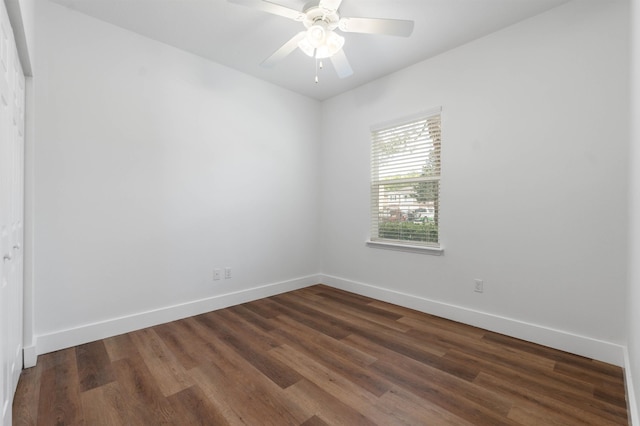 spare room with dark wood-style floors, a ceiling fan, and baseboards