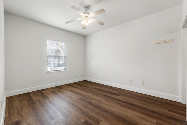 empty room with dark wood-style floors, ceiling fan, and baseboards