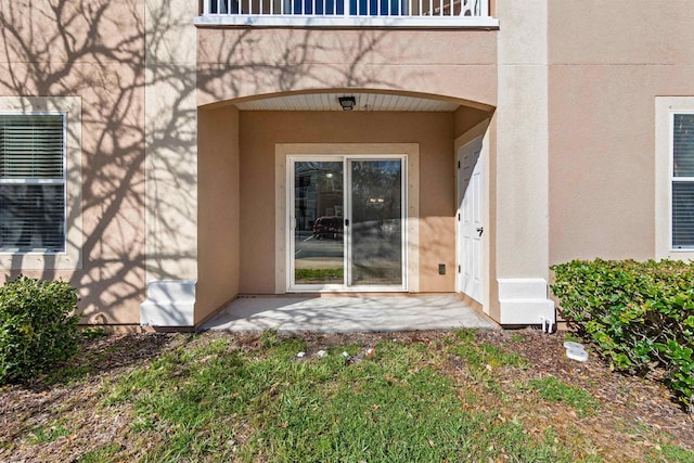 doorway to property featuring a patio area and stucco siding