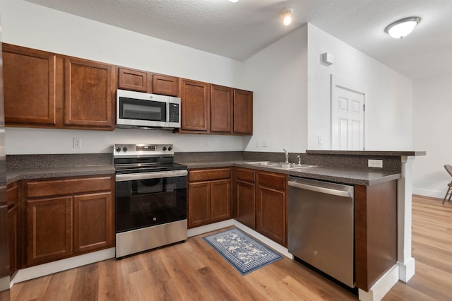 kitchen featuring dark countertops, stainless steel appliances, and a peninsula