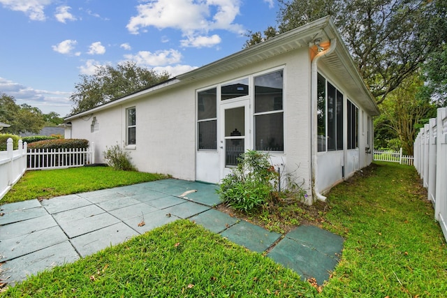 581 Boxwood Pl, Saint Augustine, FL 32086 - view of side of home featuring a sunroom, a fenced backyard, stucco siding, and a patio