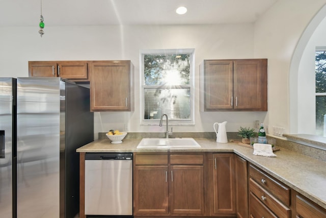 581 Boxwood Pl, Saint Augustine, FL 32086 - kitchen with stainless steel appliances, light countertops, arched walkways, and brown cabinets