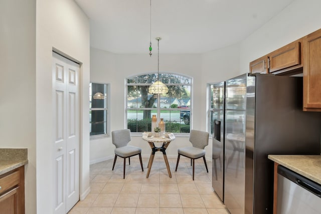 581 Boxwood Pl, Saint Augustine, FL 32086 - kitchen with stainless steel appliances, brown cabinets, hanging light fixtures, light countertops, and light tile patterned floors