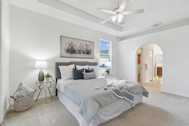 581 Boxwood Pl, Saint Augustine, FL 32086 - bedroom with arched walkways, carpet floors, a raised ceiling, ensuite bathroom, and ceiling fan