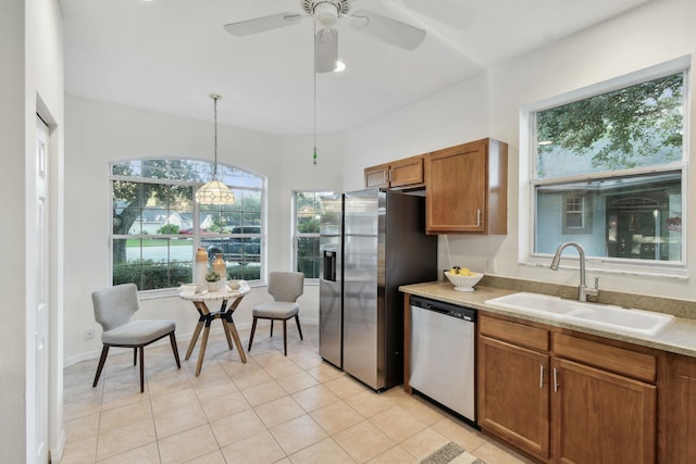 581 Boxwood Pl, Saint Augustine, FL 32086 - kitchen with stainless steel appliances, brown cabinetry, hanging light fixtures, light countertops, and ceiling fan