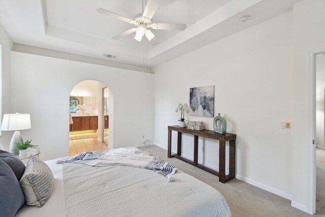 581 Boxwood Pl, Saint Augustine, FL 32086 - bedroom with arched walkways, a raised ceiling, light carpet, ensuite bathroom, and ceiling fan