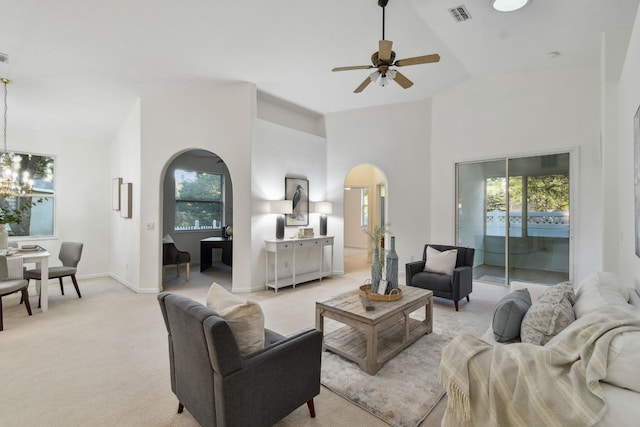 581 Boxwood Pl, Saint Augustine, FL 32086 - living room with arched walkways, a ceiling fan, light carpet, a chandelier, and high vaulted ceiling