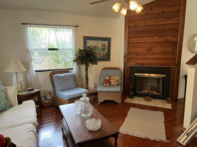 living room featuring ceiling fan, dark hardwood / wood-style flooring, and a textured ceiling