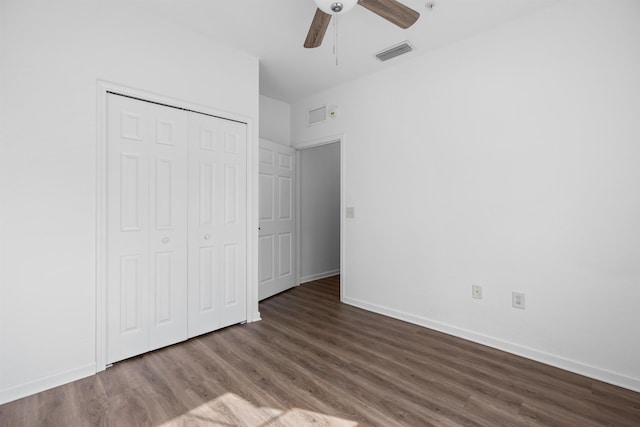 unfurnished bedroom with dark wood-type flooring, ceiling fan, and a closet