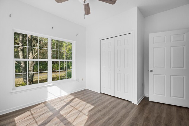 unfurnished bedroom with ceiling fan, dark hardwood / wood-style floors, and a closet