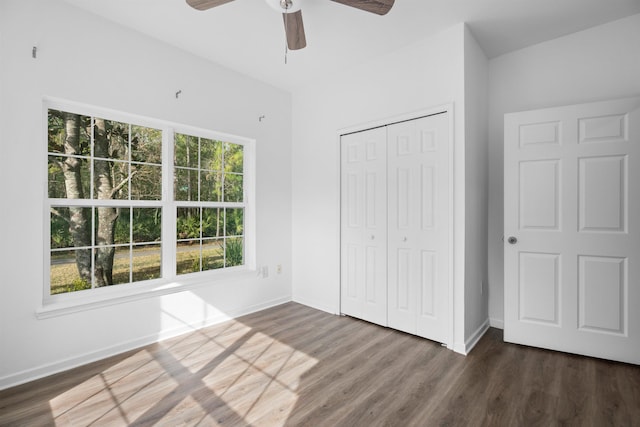 unfurnished bedroom with dark wood-type flooring, ceiling fan, and a closet