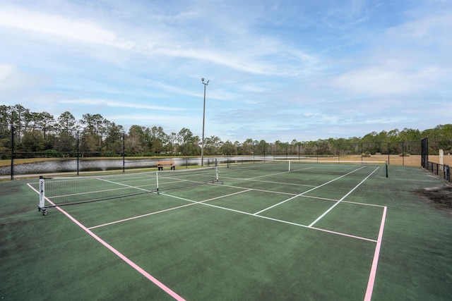 view of tennis court with a water view