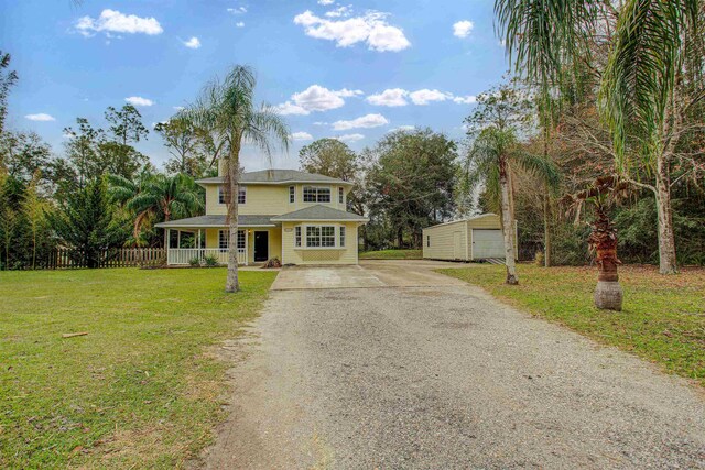 543 Ray Edwards Rd, Saint Augustine, FL 32086 - traditional-style house with a chimney, fence, a porch, a front yard, and roof with shingles