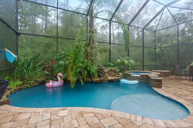 view of pool featuring an in ground hot tub, a patio, and glass enclosure