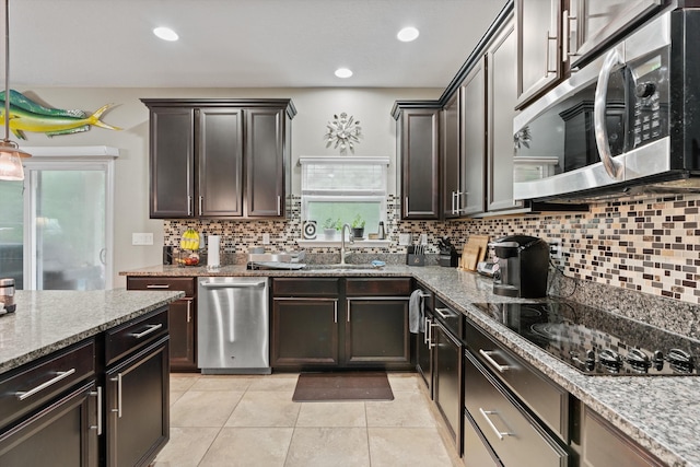 kitchen featuring light stone countertops, light tile patterned floors, dark brown cabinetry, and black electric cooktop