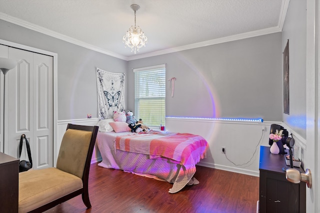 bedroom with a textured ceiling, crown molding, hardwood / wood-style flooring, a chandelier, and a closet