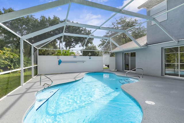 view of pool featuring glass enclosure and a patio area