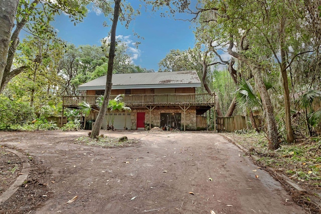 19 Casanova Rd, Saint Augustine, FL 32080 - rear view of property with a deck, stone siding, driveway, metal roof, and fence
