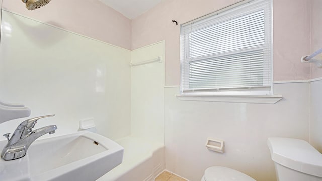 full bathroom featuring sink, tub / shower combination, and toilet