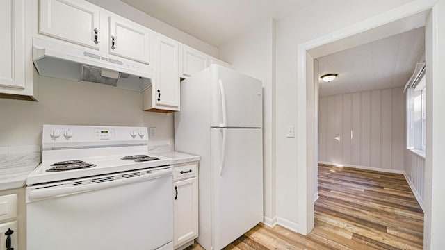 kitchen with light wood-type flooring, white appliances, white cabinetry, and light stone countertops