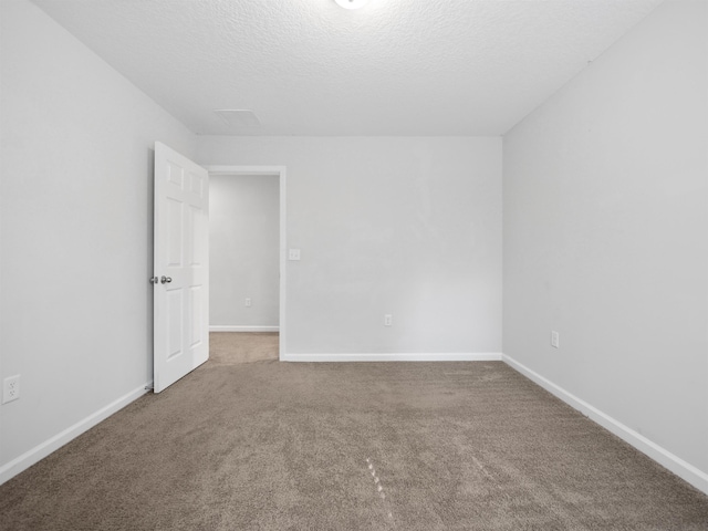 carpeted spare room featuring a textured ceiling