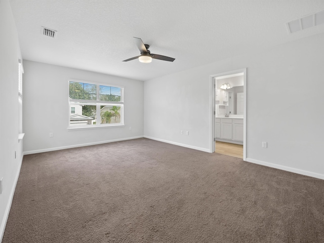 empty room featuring carpet, ceiling fan, and a textured ceiling