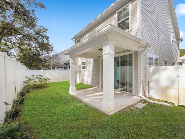 rear view of house with a yard and a patio