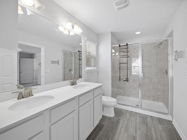 bathroom featuring vanity, toilet, and walk in shower