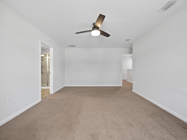 carpeted empty room with ceiling fan and a textured ceiling