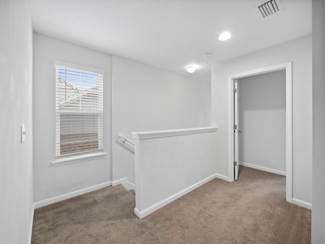 hallway featuring light carpet